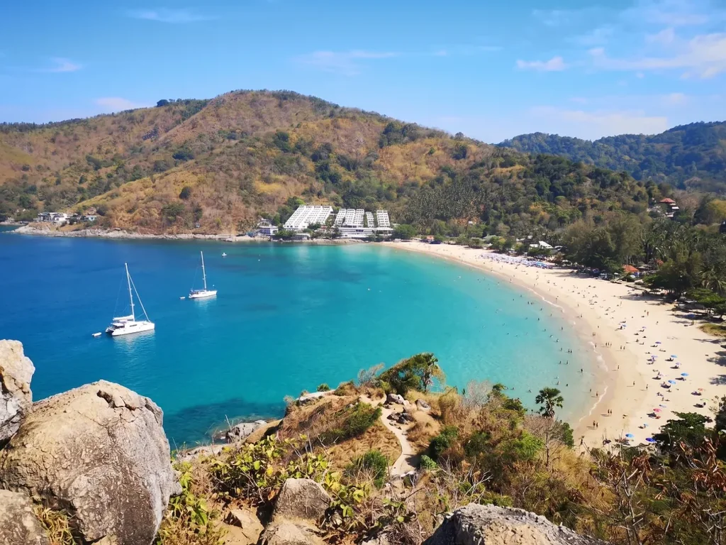 Elevated view over Nai Harn Beach, one of the three Phuket areas compared in the guide